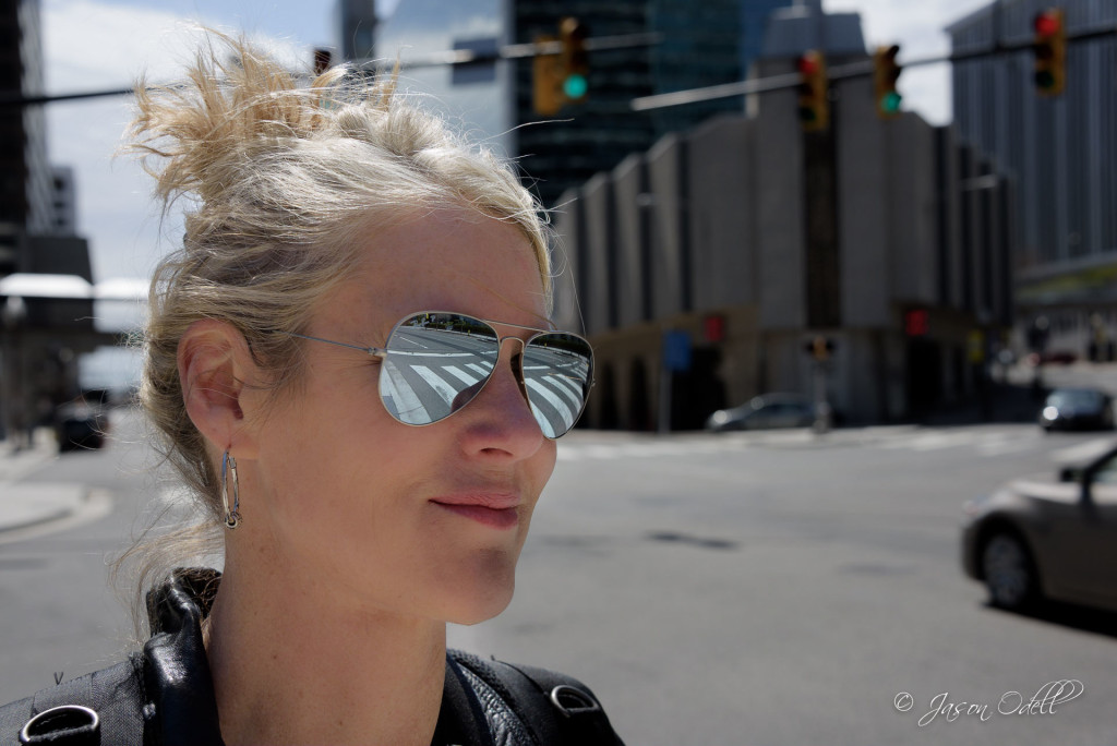 Mirrored sunglasses reflecting a city crosswalk.